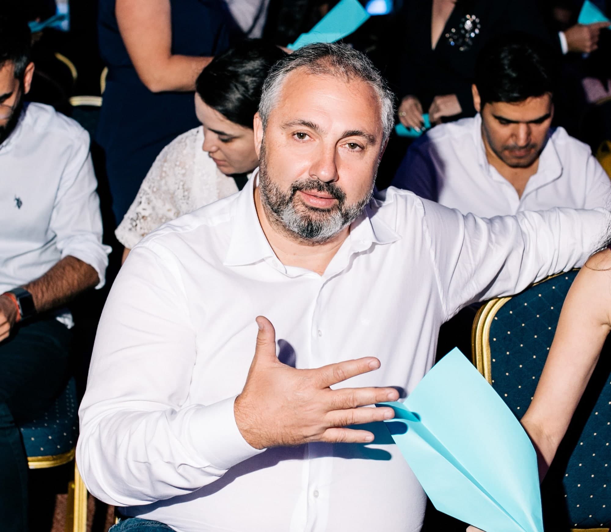 Alex Yanovsky in a white shirt at a live event